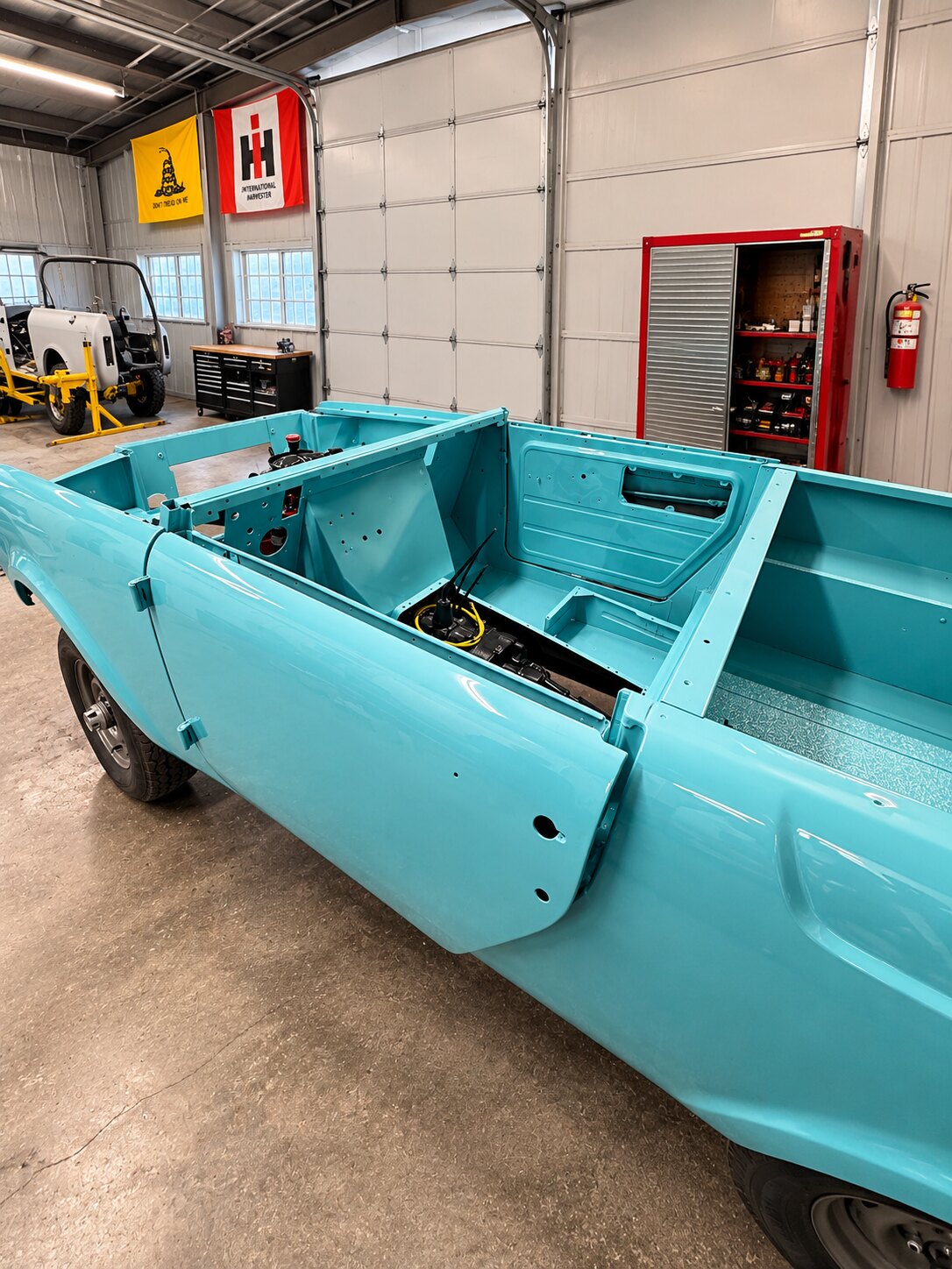 Bare tub in fresh paint, doors off